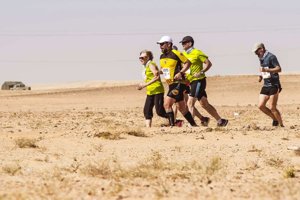 Un groupe de runners en train de courir à travers le sable