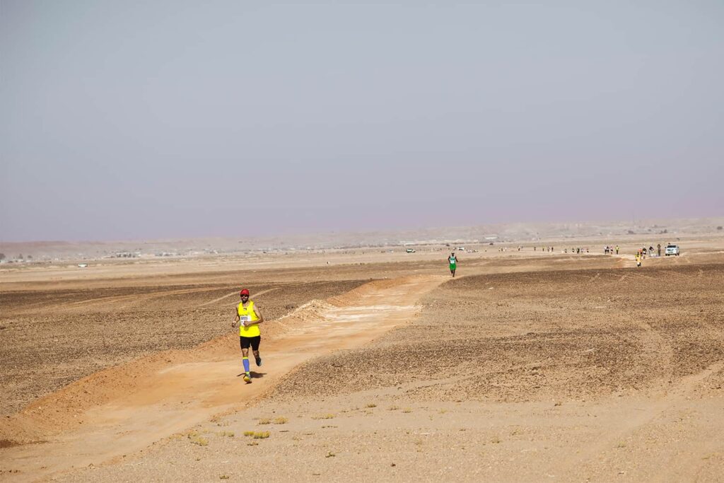 Coureur de marathon parcourent l'environnement aride du Sahara