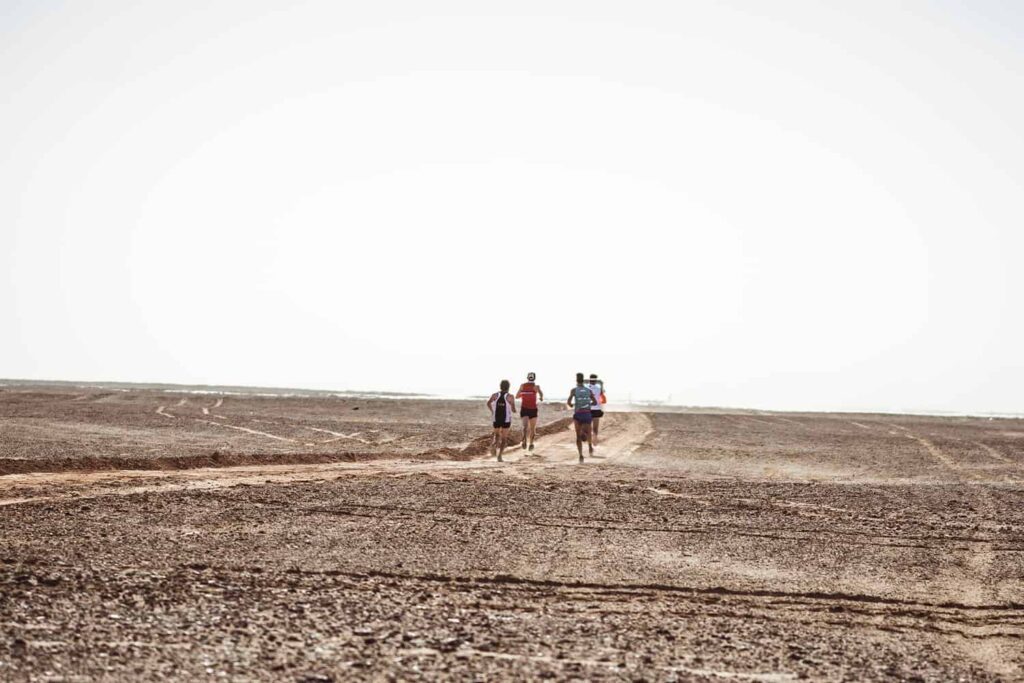 Des runners vus de dos pendant leur traversée du Sahara