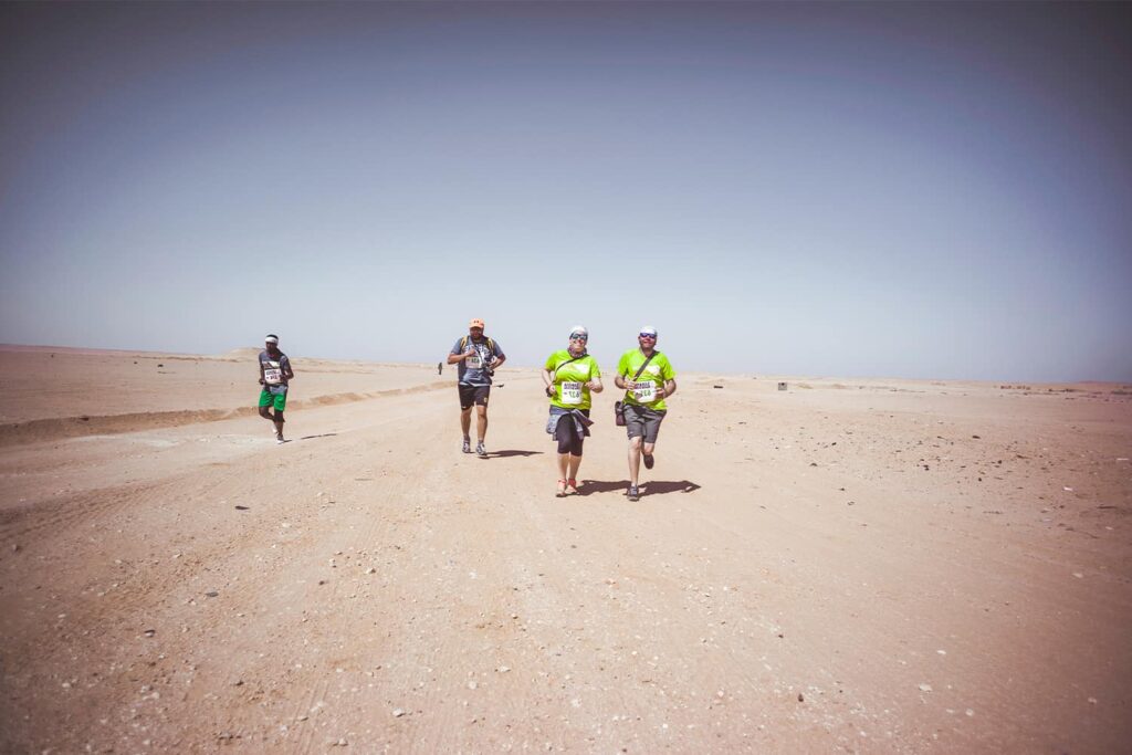 Des runners font un effort intense en pleine course au milieu du désert