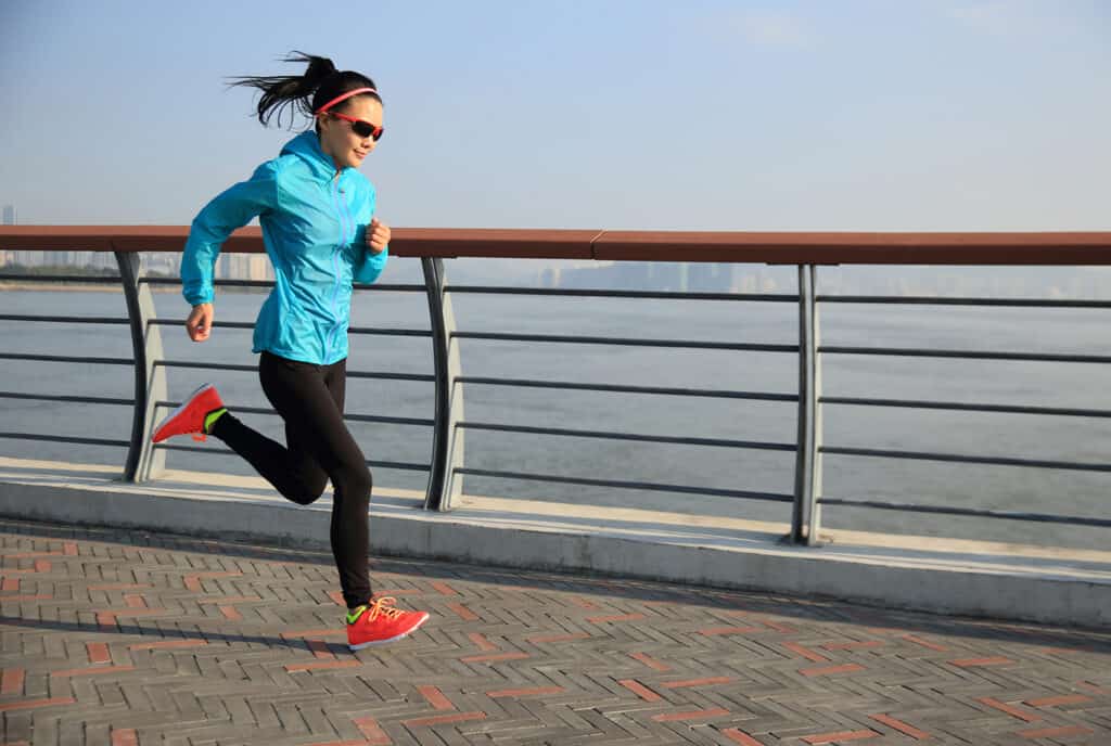 jeune femme en forme courant sur une route de bord de mer