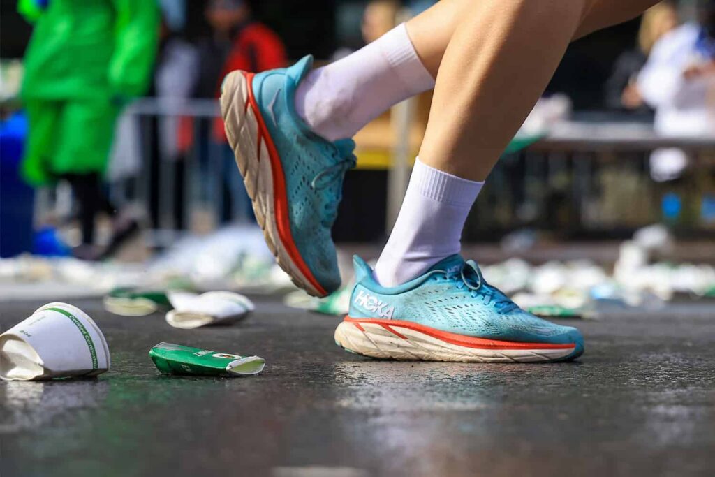 Les chaussures d'un coureur au milieu des gobelets utilisés par les concurrents