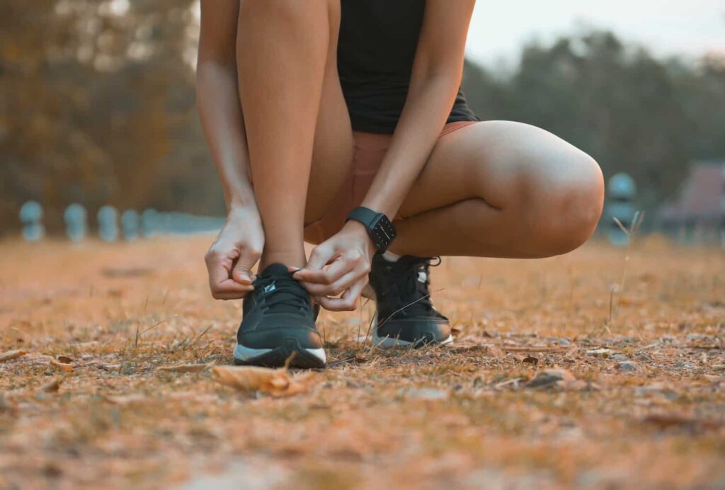 femme qui ajuste une chaussure de trail