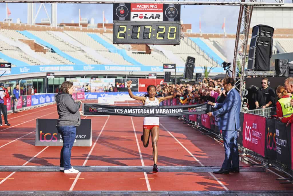 Almaz Ayana sur la ligne d'arrivée du marathon d'Amsterdam avant le reste des finishers