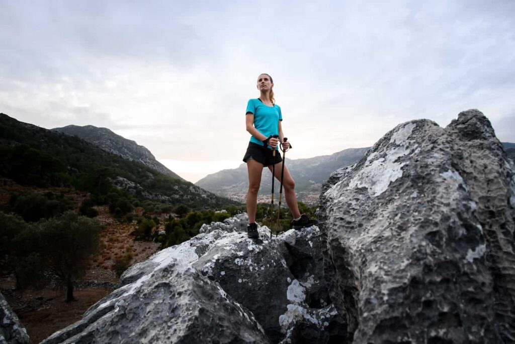 femme avec bâtons de trail fast hiking