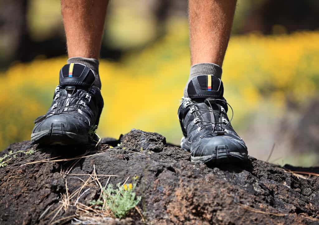 Chaussures de randonnée en gros plan sur de la terre aux pieds d'un marcheur