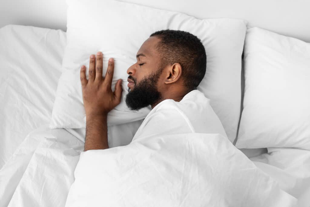 runner calme dormant sur un lit blanc