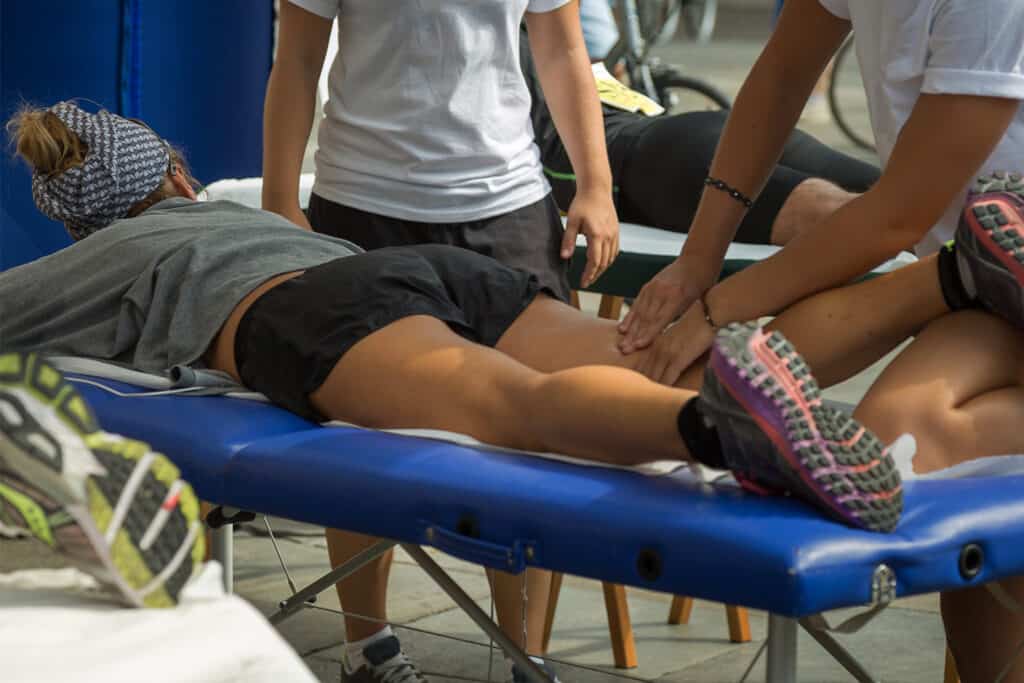 une coureuse se fait masser par un professionnel post marathon
