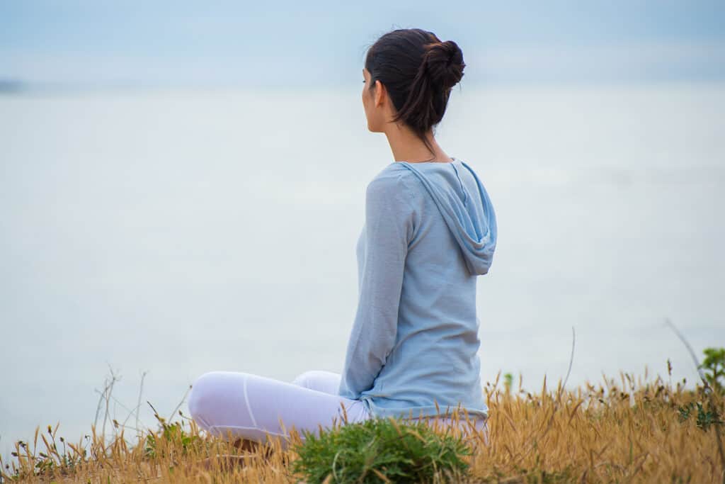 jeune coureuse qui médite avec pour objectif de reposer son mental