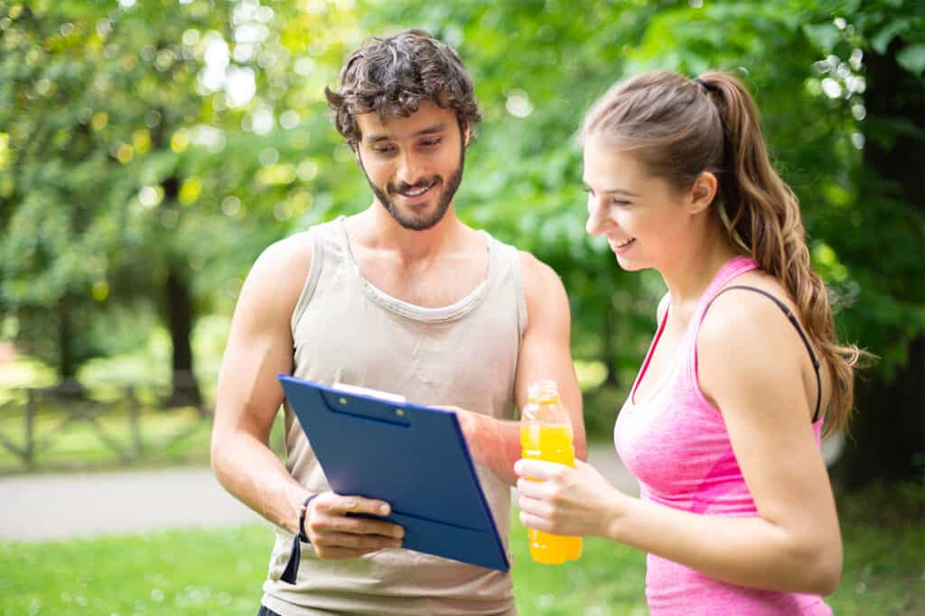 une runneuse discute avec son coach de comment récupérer après une course en reposant son organisme