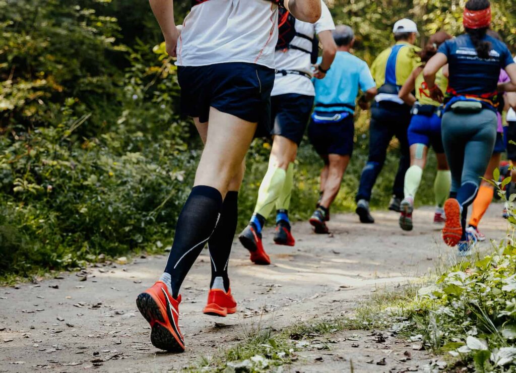 équipe de coureurs en runnings sur un chemin de terre