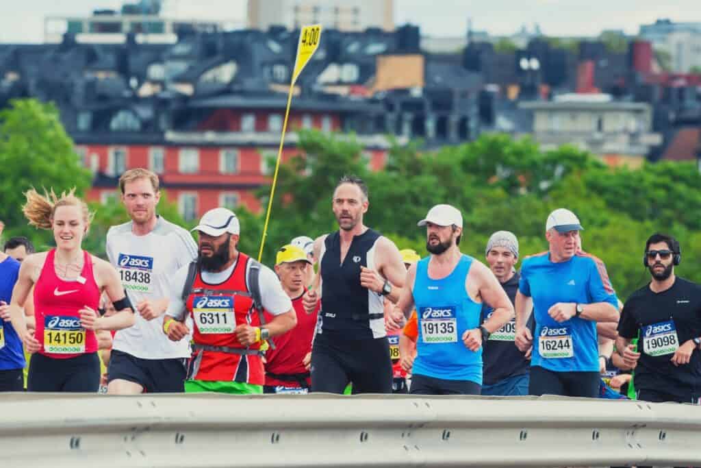 athlète portant un drapeau d'allure et mène un groupe de runners