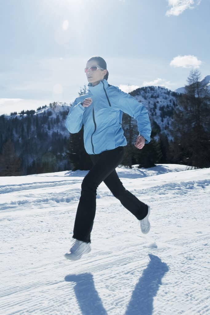 runneuse en montagne sur un sentier enneigé