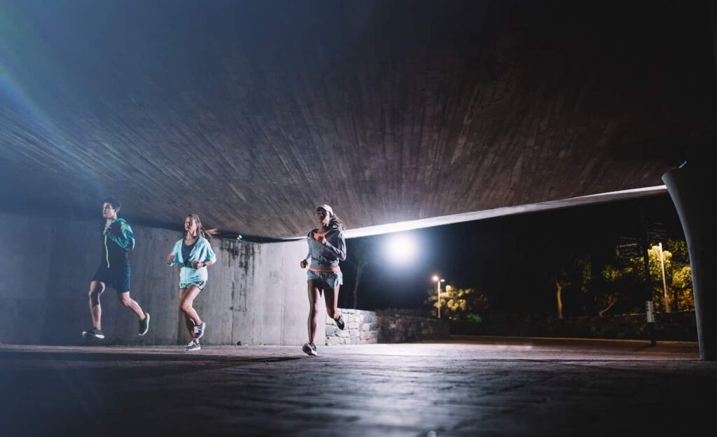 Groupe de runners la nuit qui alterne temps d'effort et repos en fartlek