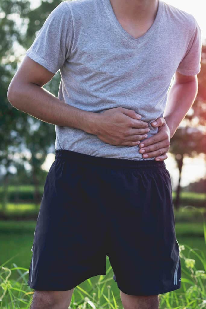 Homme qui se tient l'estomac car il a couru après manger