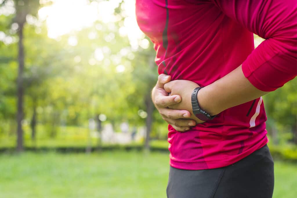 une femme a un point de coté pendant l'effort physique