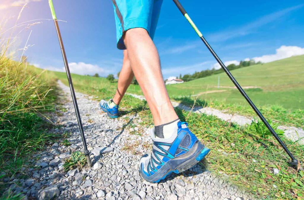 marcheur nordique sur chemin avec graviers