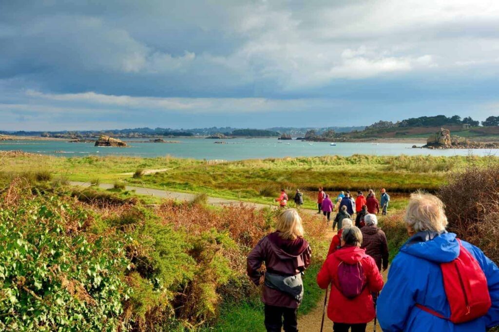 groupe de personnes marchant sur le sentier GR34 en Bretagne.