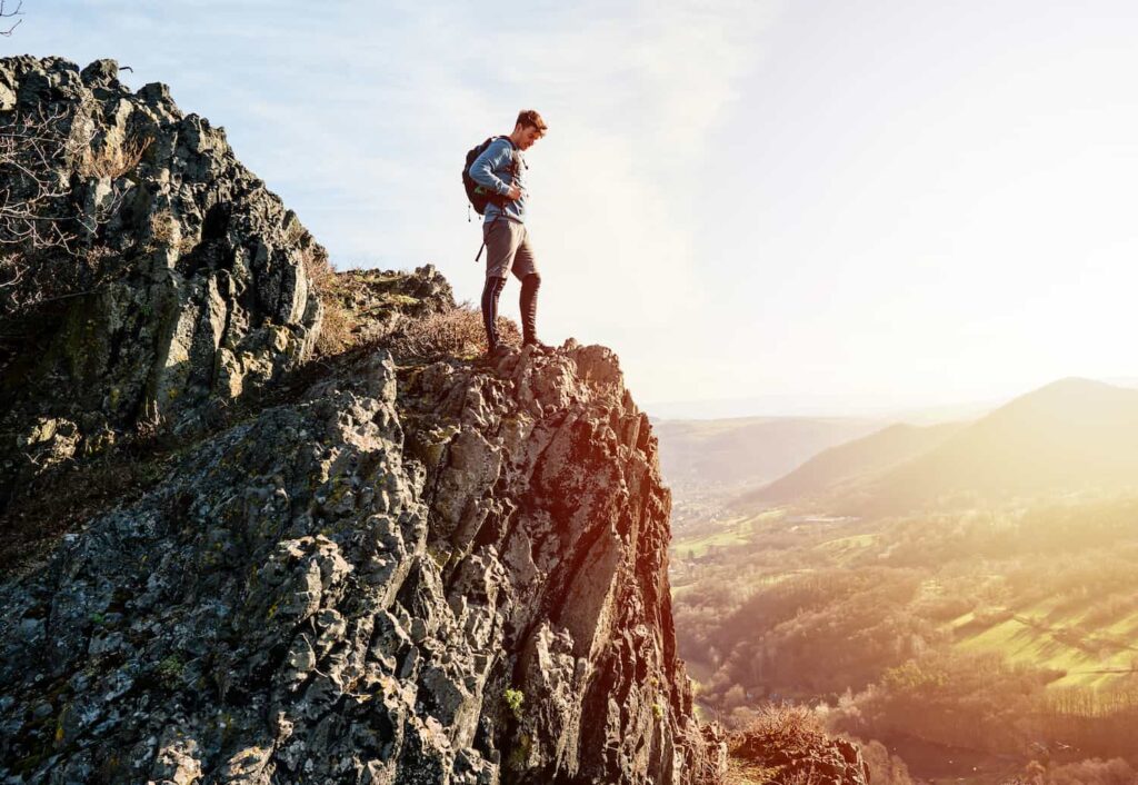 homme avec chaussures de randonnée basses équipées de pare-pierres qui contemple la nature magnifique