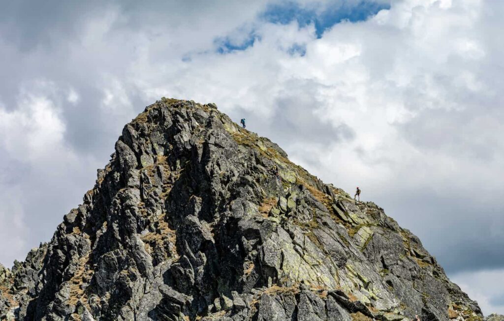 hommes avec sacs à dos et chaussures de randonnée sur des sentiers en montagne alpine qui demande une bonne accroche