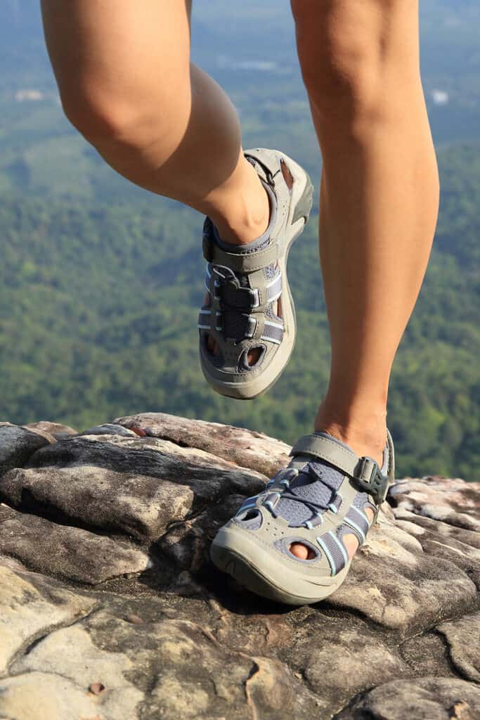 jeune femme randonneuse au sommet d'une montagne rocheuse