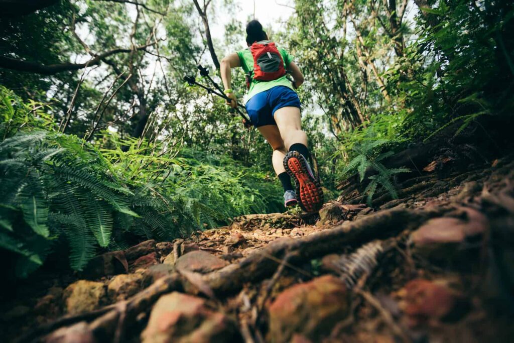 femme en course d'ultra-trail sur des sentiers escarpés avec beaucoup de dénivelé