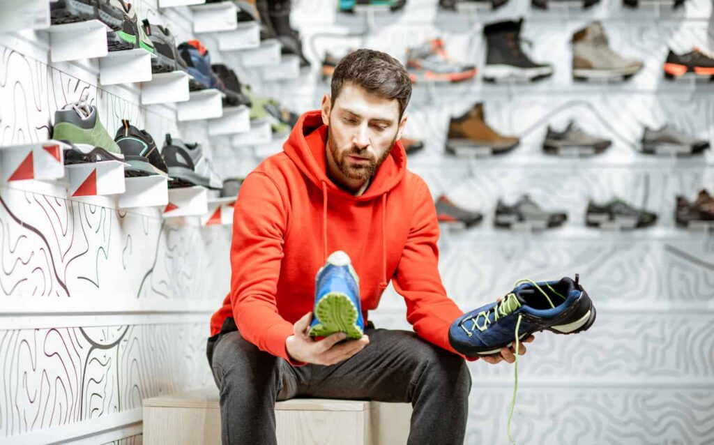 vendeur homme qui conseille comment choisir chaussures trail